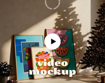 May include: Three framed art prints with colorful designs lean against a wall. The frames have gold and blue borders. The text "video mockup" is displayed on the image. A Christmas tree is in the background.