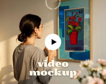 Puede incluir: Una obra de arte enmarcada que presenta una maceta roja con flores rojas y hojas verdes, etiquetada como "LA MACETA" y "52". La obra de arte se exhibe en una pared. La imagen también incluye el texto "video mockup" y el logotipo de motionmockups.