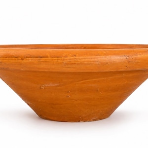 May include: A wide, shallow terracotta bowl with a smooth, matte finish and a thick, rounded rim. The bowl features a conical shape that tapers down to a flat base, showcasing a natural, earthy orange-brown color throughout the surface.