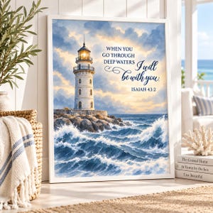 May include: A framed wall art print featuring a lighthouse on a rocky shore with crashing blue waves. The sky is filled with soft clouds. The text reads: WHEN YOU GO THROUGH DEEP WATERS I will be with you. ISAIAH 43:2 in dark blue lettering.