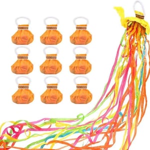 May include: Nine orange party favors with white handles are arranged in a grid. A yellow decoration with colorful streamers is on the right. The streamers are in shades of orange, pink, green, and blue.