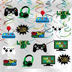 May include: A collection of gaming-themed decorations featuring controllers, headphones, and arcade joysticks. Text includes "Level Up", "Game Over", "You Win!", and "Get Your Game On". The decorations are in black, white, green, red, and blue.
