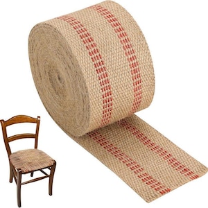 May include: A roll of natural burlap ribbon with vertical red stripes. The ribbon is unrolled, revealing its texture and pattern. A wooden chair with a woven seat is in the background, suggesting a craft or home decor theme.