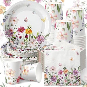 May include: White paper plates, cups, and napkins with a floral and butterfly design. The plates and napkins have a border of pink, purple, and yellow flowers. The cups have a similar floral pattern. A stack of plates and napkins are visible.