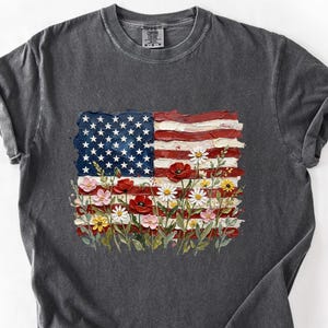 A gray t-shirt with a design featuring the American flag and flowers.