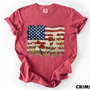 A red t-shirt with an American flag design and colorful flowers printed on it.