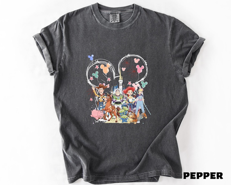 A gray t-shirt with a colorful graphic design featuring characters from the Toy Story movie, including Woody, Buzz Lightyear, and other beloved characters.