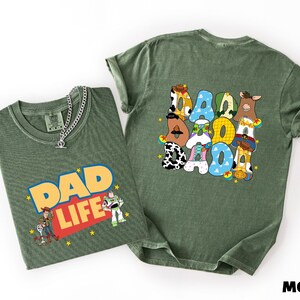 two green t-shirts with cartoon characters and text on them.