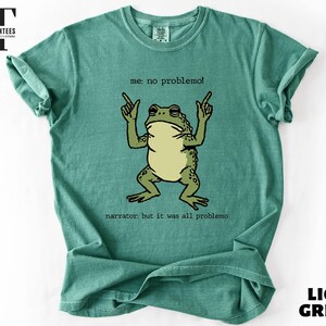 a green t-shirt with a cartoon frog and text printed on it.