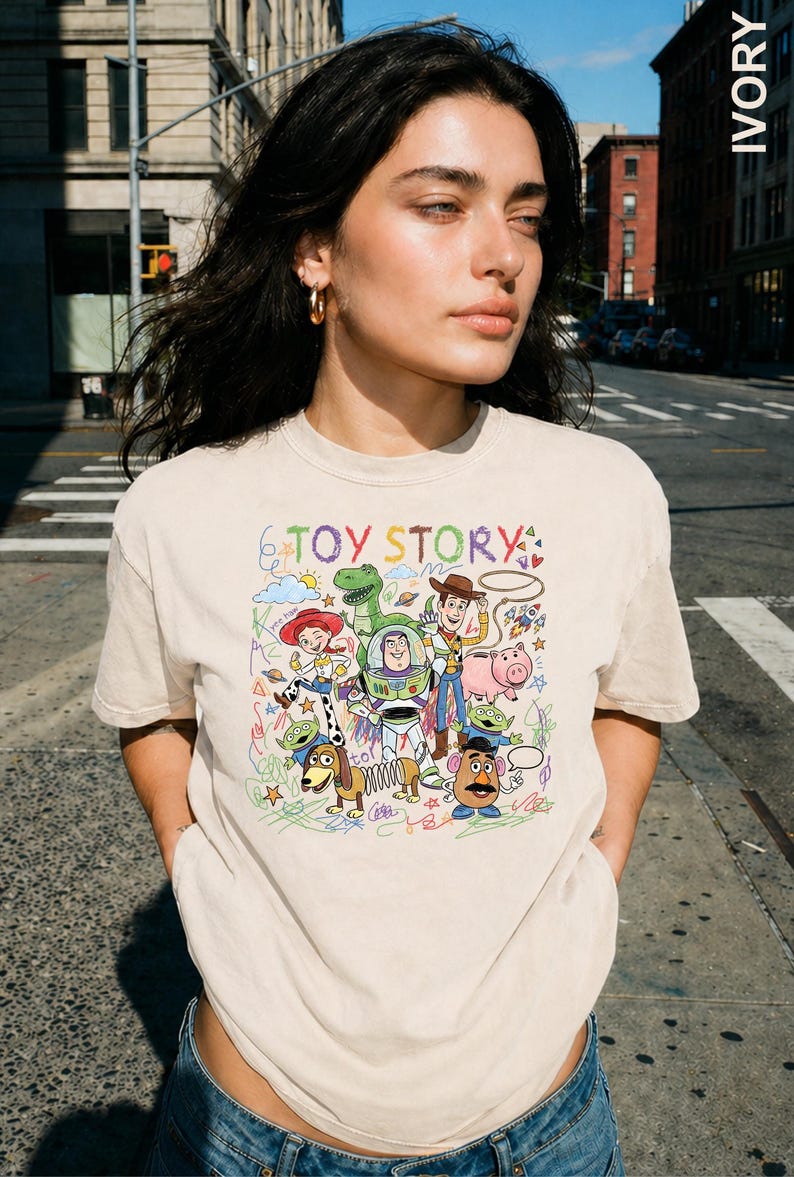 A young woman wearing a t-shirt with a colorful graphic of characters from the Toy Story movie.