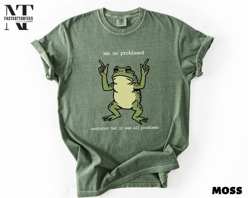 A green t-shirt with a cartoon frog and text printed on it.