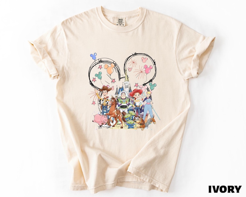 A white t-shirt with a colorful graphic design featuring various cartoon characters and Disney-themed elements.