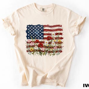 A white t-shirt with a graphic design depicting the American flag and flowers.