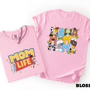 two pink t-shirts with cartoon characters and text on them.