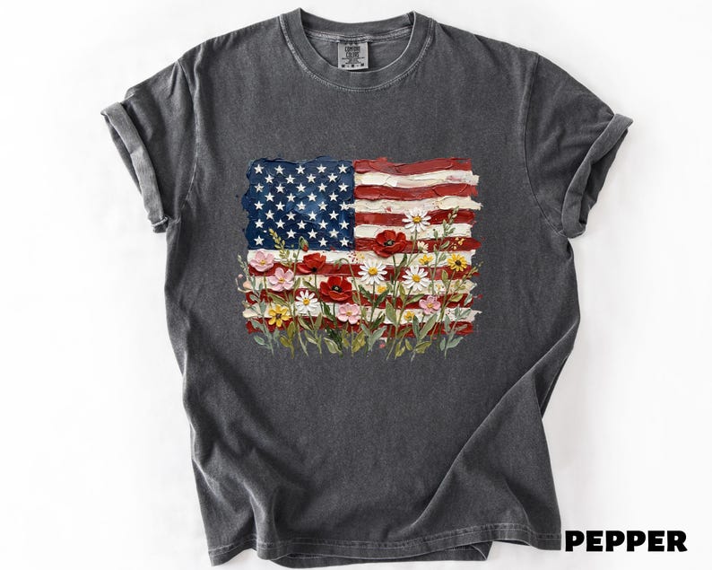 A gray t-shirt with a design featuring the American flag and flowers.