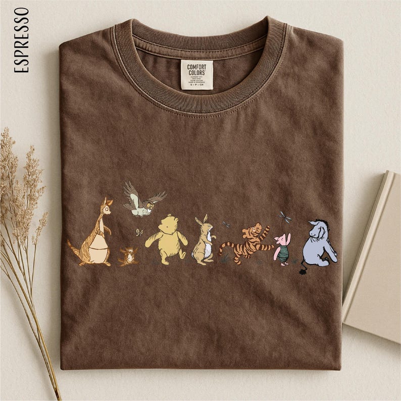 A brown t-shirt with a line of colorful cartoon animal characters printed on it, including a kangaroo, bear, tiger, pig, and elephant.