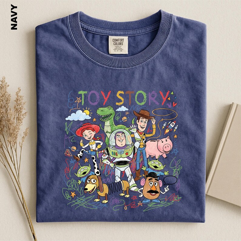A navy blue t-shirt with a colorful graphic design featuring characters from the Toy Story movie, including Woody, Buzz Lightyear, and other beloved characters.