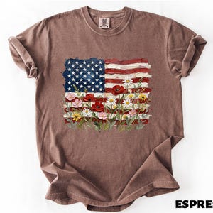 A brown t-shirt with an American flag design and colorful flowers printed on it.