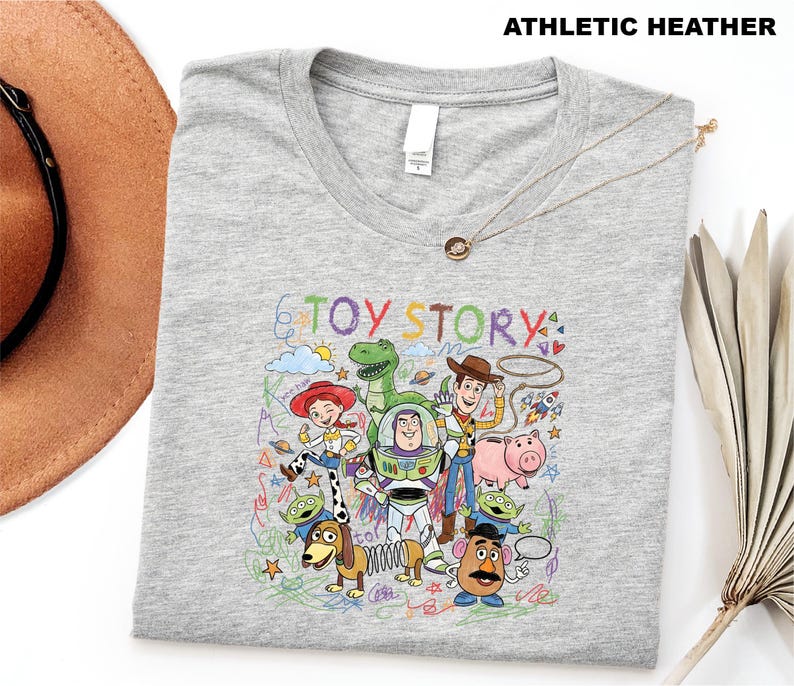 A gray t-shirt with a colorful graphic design featuring characters from the Toy Story movie, including Woody, Buzz Lightyear, and other beloved characters.