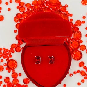 Ruby oval stud earrings in a decorative jar