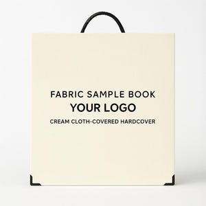 May include: Cream-coloured fabric sample book with a black handle. The cover displays the text "FABRIC SAMPLE BOOK" and "YOUR LOGO" in black, with "CREAM CLOTH-COVERED HARDCOVER" below. Black corner protectors are visible.