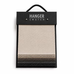Könnte beinhalten: Ein Stoffmusterbuch mit einem schwarzen Kopfbereich, der den Text HANGER SWATCH und einen schwarzen Kordelgriff aufweist. Das Buch enthält mehrere quadratische Stoffmuster mit gezackten Kanten, die farblich von Beige bis Anthrazit reichen.