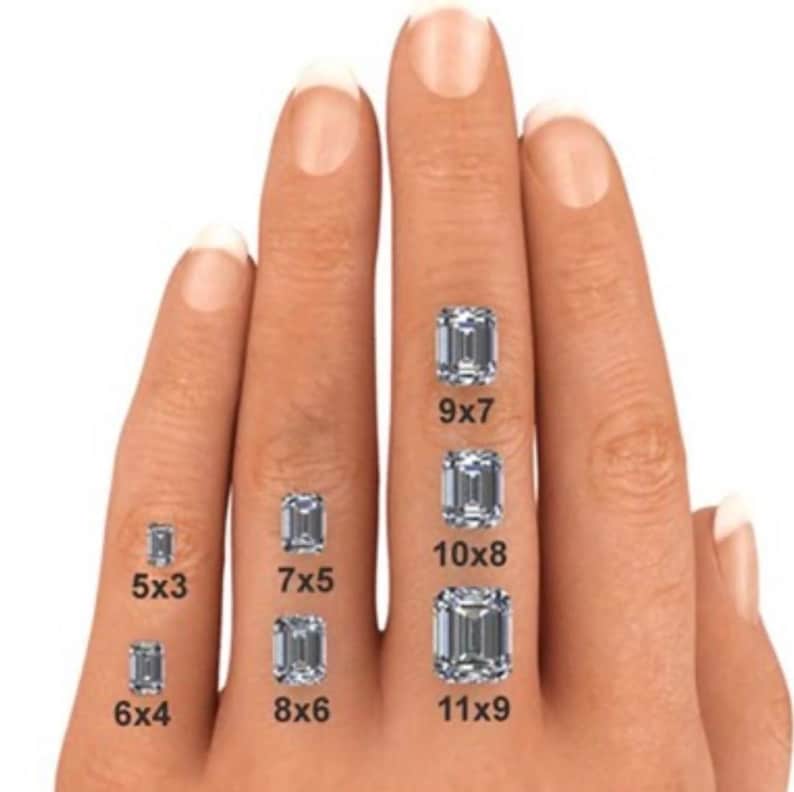 May include: A hand displaying various emerald-cut diamond sizes. The sizes are labeled: 5x3, 6x4, 7x5, 8x6, 9x7, 10x8, and 11x9. The diamonds are clear and sparkling, showcasing their rectangular shape.