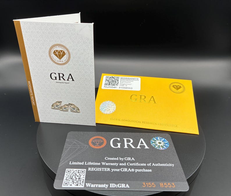 May include: A set of GRA documents, including a Moissanite Report, warranty card, and certificate of authenticity. The documents feature the GRA logo, QR codes, and text such as "Limited Lifetime Warranty" and "Register your GRA purchase."
