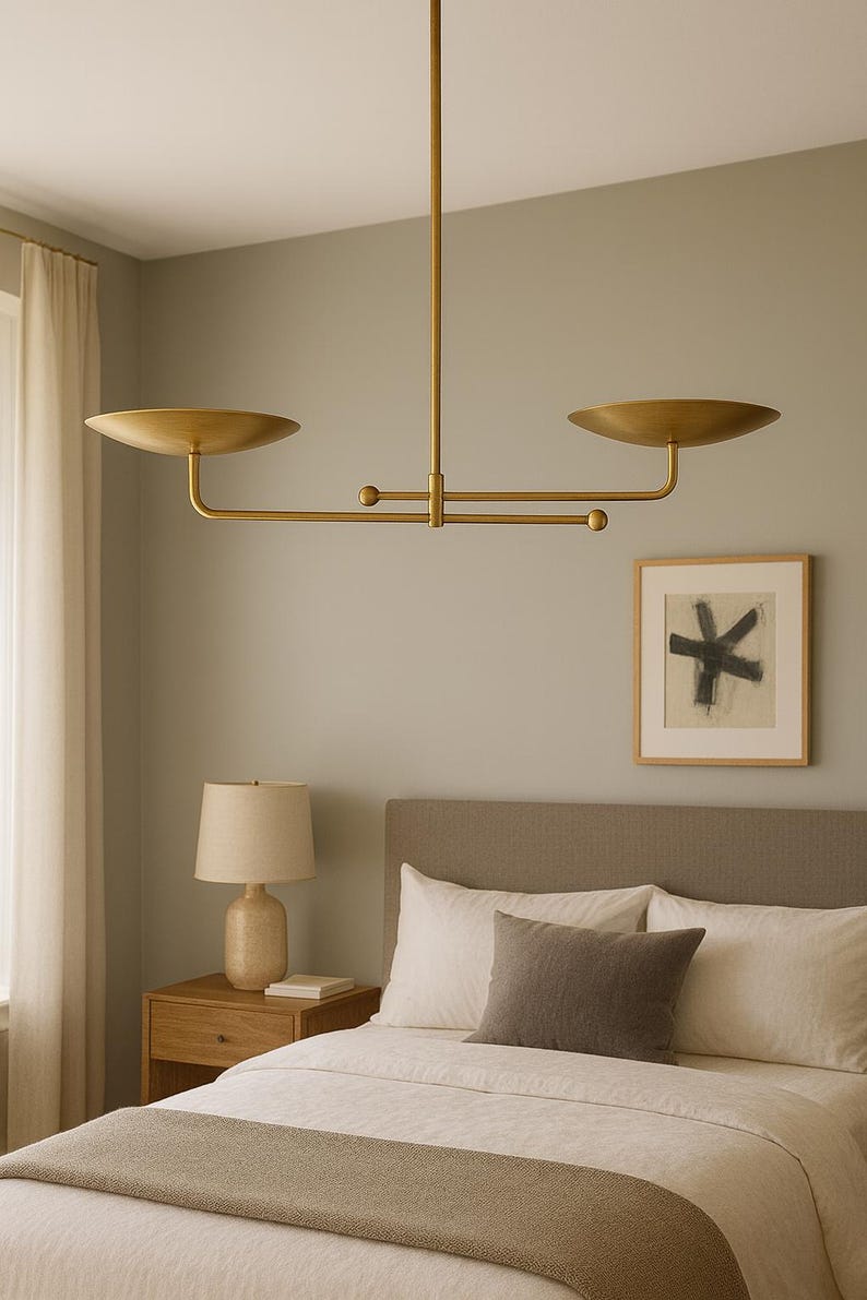 Modern brass linear chandelier with two dish-shaped shades hanging above a minimalist gray and white bedroom interior
Handmade brass pendant light fixture with dual disc shades in a modern bedroom with neutral décor
Luxury brushed brass two-arm linear chandelier installed above a bed in a contemporary minimalist room
Mid century modern brass ceiling light with two flat dome shades illuminating a cozy bedroom interior