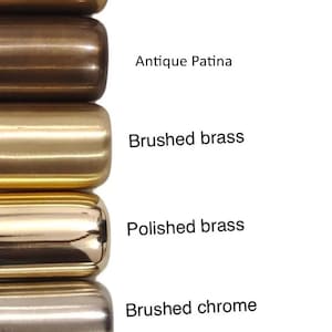 May include: A vertical image showcasing a series of metal finishes. The finishes include brushed antique brass, antique black, blackened brass, raw brass, antique patina, brushed brass, polished brass, brushed chrome, polished chrome, matte black, and matte white.