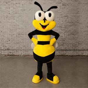 May include: A full-body bee mascot costume featuring a large, round head with oversized white eyes, black antennae, and a smiling mouth. The body has horizontal yellow and black stripes, black sleeves, black trousers, and yellow and black shoes.