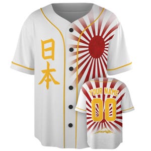 May include: A white baseball jersey featuring a red rising sun graphic on the front and back, yellow trim, and black buttons. The front displays the Japanese characters for Japan in yellow, while the back shows the text YOUR NAME and the number 00.