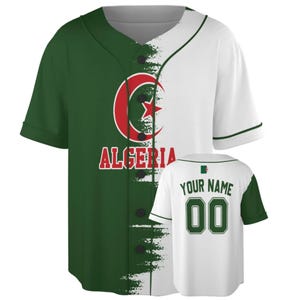Peut inclure: Un maillot de baseball à manches courtes avec un design divisé en vert et blanc. Le devant affiche un emblème rouge en forme de croissant et d'étoile au-dessus du texte ALGERIA. Le dos présente le texte YOUR NAME et le numéro 00.