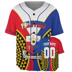 Puede incluir: Una camiseta de béisbol de manga corta con los colores de la bandera de Filipinas, rojo, blanco y azul. El frente muestra el texto PHILIPPINES, un emblema central de escudo y una bandera de Republic of the Philippines. La espalda muestra YOUR NAME y 00.
