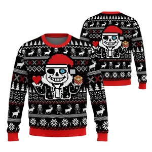 May include: A black long-sleeve jumper featuring a pixelated character wearing a red Santa hat, holding a red heart and a gift box. The design includes repeating patterns of reindeer, snowflakes, and smaller character figures in red and white.