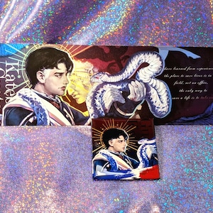 May include: Artwork depicting a person with a snake, with the text "Kate Gustave". The artwork is in blue, red, and white. The artwork also includes text that reads "have learned from experience that the place to save lives is in the field, not an office."