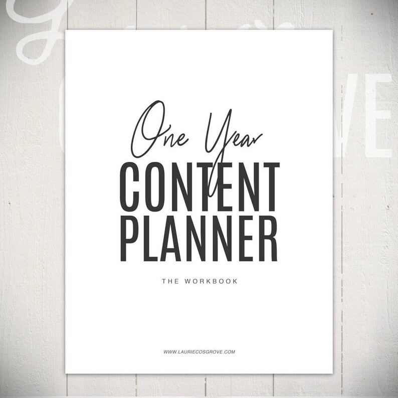 May include: A white sheet of paper with black text that reads "One Year Content Planner The Workbook www.lauriecoshgrove.com".