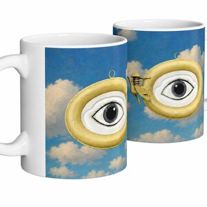 Peut inclure: Mug en céramique blanche avec un design surréaliste. Le motif représente deux objets en forme d'œil à bordure jaune sur un fond de ciel bleu et de nuages. Les yeux ont des pupilles noires et des iris blancs. La tasse a une anse blanche.