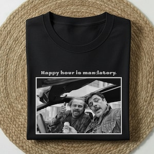 Könnte beinhalten: Schwarzes Sweatshirt mit Rundhalsausschnitt und dem Text "Happy hour is mandatory." Darunter ist ein Schwarz-Weiß-Bild von zwei Männern in einem Auto abgedruckt. Einer der Männer hält eine Bierdose.