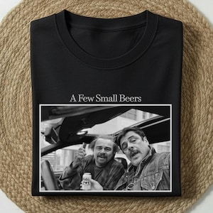 May include: Black crew neck sweatshirt with the text "A Few Small Beers" above a black and white image of two men in a car. One man holds a beer can.