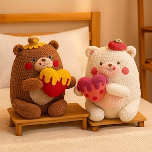 May include: Two plush bear figures, one brown and one white, each holding a heart-shaped pillow. The brown bear has a yellow and red heart, while the white bear has a pink and red heart. Both bears sit on small wooden platforms.