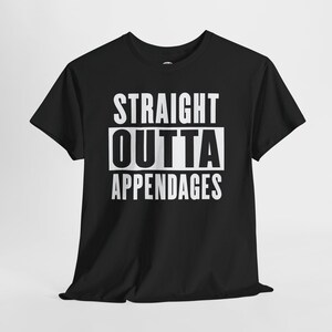 Può includere: T-shirt nera con la scritta bianca "STRAIGHT OUTTA APPENDAGES". Il testo è disposto su tre righe, con "OUTTA" in un rettangolo bianco. La maglietta ha maniche corte e girocollo.