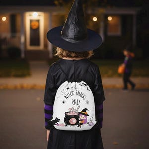Op de afbeelding: Een kind in een zwart heksenkostuum en hoed, met een witte rugzak met trekkoord. De rugzak heeft een ketelafbeelding met de tekst "Witchy Snacks Only". De achtergrond toont een voorstedelijke straat 's nachts.