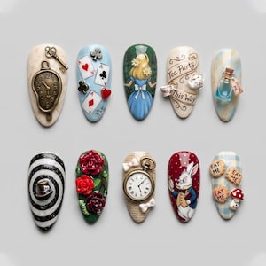 May include: A collection of ten almond-shaped nail designs featuring Alice in Wonderland themes. Designs include playing cards, a pocket watch, Alice in a blue dress, a tea party scene, and the White Rabbit. Some nails have text that says "Drink Me" and "Eat Me".
