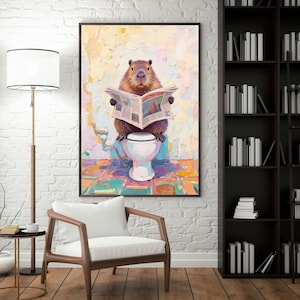 May include: A framed art print depicts a capybara sitting on a toilet, engrossed in a newspaper. The artwork features a colorful, textured background and a white toilet. The capybara is brown with a focused expression.