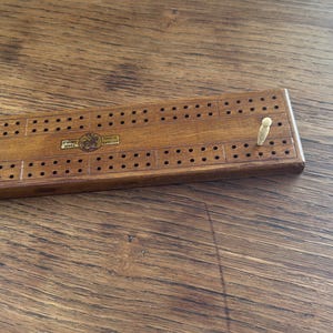 vintage wood cribbage board with pegs and cards