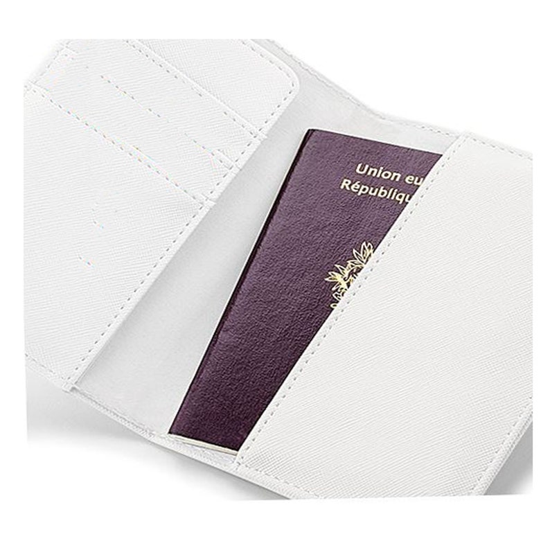 May include: White passport holder with a burgundy passport inside. The passport has the text "Union europ&eacute;enne R&eacute;publique fran&ccedil;aise" on the cover.