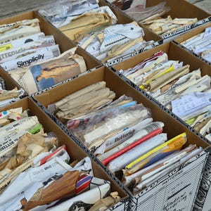 May include: Multiple cardboard storage boxes filled with assorted vintage sewing patterns. The boxes contain various paper envelopes featuring brand names like Simplicity, Butterick, and McCall's, with visible illustrations and printed text.