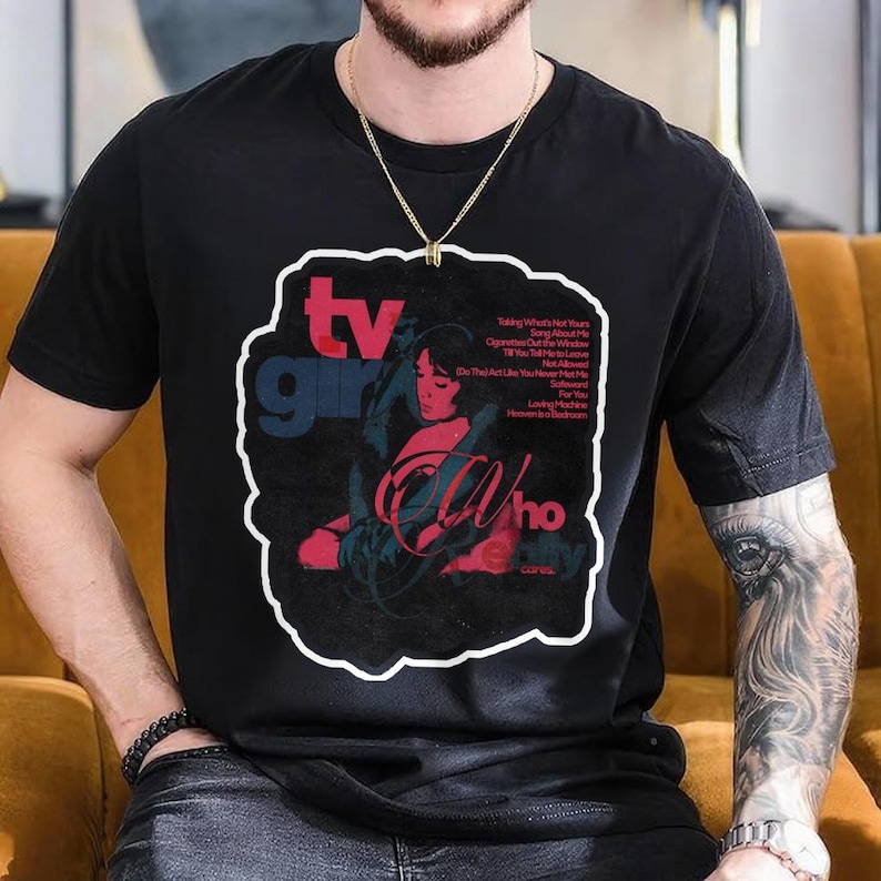 K&ouml;nnte beinhalten: Schwarzes T-Shirt mit einem grafischen Design mit dem Text "tv girl" in Blau und Rot und dem Wort "Who" in Rot. Das Design enth&auml;lt ein Portr&auml;t einer Frau und Songtitel.
