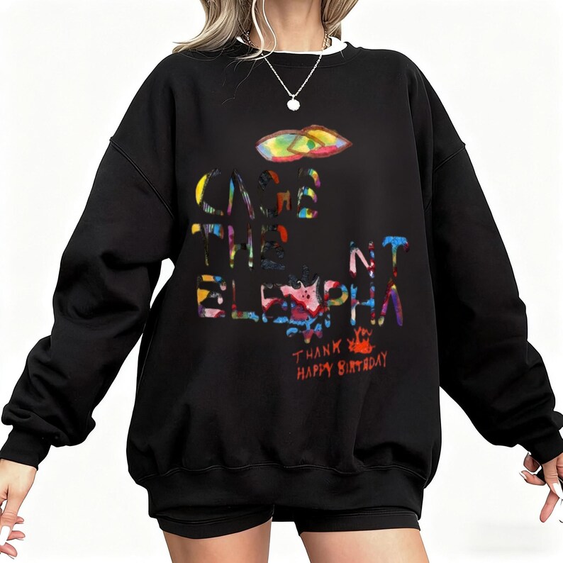 May include: Black sweatshirt with the text "CAGE THE ELEPHANT" in colorful, stylized letters. A colorful graphic of a shape is above the text. The words "THANK YOU HAPPY BIRTHDAY" are below the text.